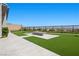Large backyard with a fire pit feature, green grass, and a wrought-iron fence at 5166 Stone View Dr, Las Vegas, NV 89135