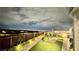 Well-lit backyard with artificial grass, a fire pit, and a fence providing privacy and a view of the surrounding area at 5166 Stone View Dr, Las Vegas, NV 89135