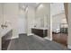 Open bathroom layout featuring dual vanities, dark cabinets, gray tile floor, and a glimpse into bedroom at 5166 Stone View Dr, Las Vegas, NV 89135