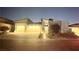 Charming single-story home featuring a three-car garage and beautifully illuminated at dusk at 5166 Stone View Dr, Las Vegas, NV 89135