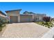 Contemporary home featuring a three-car garage, modern architecture, and desert landscaping on a sunny day at 5166 Stone View Dr, Las Vegas, NV 89135