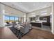 Spacious living room with a kitchen area, hardwood floors and large windows offering an expansive view at 5166 Stone View Dr, Las Vegas, NV 89135