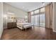 Serene bedroom featuring hardwood floors, neutral colors, and a large window with custom drapery at 5166 Stone View Dr, Las Vegas, NV 89135
