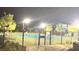Community pool area at night behind a wrought iron fence with a paved entry and desert landscaping at 5166 Stone View Dr, Las Vegas, NV 89135