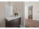 Elegant powder room boasts a modern vanity with marble countertop and wood floors at 5166 Stone View Dr, Las Vegas, NV 89135