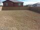 Spacious backyard with gravel, surrounded by a block wall for privacy and security at 5308 La Quinta Hills St, North Las Vegas, NV 89081