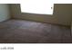 A sunlit bedroom featuring neutral carpeting and a large window, creating a bright and inviting space at 5308 La Quinta Hills St, North Las Vegas, NV 89081