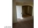 Entryway with white door, tan carpet, and tile with an arched doorway leading to another room at 5308 La Quinta Hills St, North Las Vegas, NV 89081