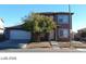 Two-story home with a two car garage, small tree and neutral colored exterior in a residential neighborhood at 5308 La Quinta Hills St, North Las Vegas, NV 89081