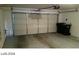 Spacious two-car garage with automatic door opener, ample storage space, and concrete flooring for parking convenience at 5308 La Quinta Hills St, North Las Vegas, NV 89081