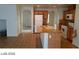 Open kitchen with tile flooring, granite counters, wood cabinets, and modern white appliances at 5308 La Quinta Hills St, North Las Vegas, NV 89081