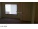 Living room with beige carpet, neutral walls, window with blinds, and a white door at 5308 La Quinta Hills St, North Las Vegas, NV 89081