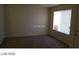 Living room with beige carpet, neutral walls, window with blinds, and a white door at 5308 La Quinta Hills St, North Las Vegas, NV 89081