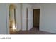 Spacious main bedroom with neutral colors and an arched entry to the ensuite bathroom at 5308 La Quinta Hills St, North Las Vegas, NV 89081