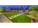 Landscaped backyard with artificial grass, pavers, pool, and a basketball court perfect for entertaining at 5480 Oatfield St, North Las Vegas, NV 89081