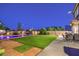 Inviting backyard featuring a pool, basketball hoop, artificial turf, and outdoor seating area at 5480 Oatfield St, North Las Vegas, NV 89081