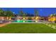 Relaxing backyard featuring a pool, hammock, a basketball hoop, and artificial grass at 5480 Oatfield St, North Las Vegas, NV 89081