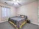 Bedroom with gray carpet and bedding, ceiling fan, and white curtains at 5480 Oatfield St, North Las Vegas, NV 89081
