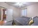 Bedroom with gray carpet and bedding, ceiling fan and an open door at 5480 Oatfield St, North Las Vegas, NV 89081