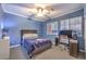 Cozy bedroom with blue walls, carpet, fan, and built-in desk featuring natural light from the window at 5480 Oatfield St, North Las Vegas, NV 89081