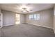 Bright bedroom with gray carpet, ceiling fan and two windows at 5480 Oatfield St, North Las Vegas, NV 89081