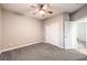 Simple bedroom with gray carpet, large closet, ceiling fan, and white trim at 5480 Oatfield St, North Las Vegas, NV 89081