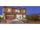 Inviting home featuring a well-lit exterior, attached garage, and attractive desert landscaping at 5480 Oatfield St, North Las Vegas, NV 89081