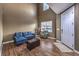 Bright living room features high ceilings, wood floors, and a comfortable blue sectional at 5480 Oatfield St, North Las Vegas, NV 89081