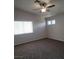 Carpeted bedroom featuring a ceiling fan and natural light from the windows at 5509 Big Sky Ln, Las Vegas, NV 89149