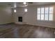 Open living space with wood floors, ceiling fan, fireplace and large windows at 5509 Big Sky Ln, Las Vegas, NV 89149