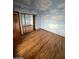 Bedroom featuring faux-painted sky walls, wood floors and closet with mirrored doors at 600 Woodmount Dr, Las Vegas, NV 89107
