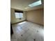 Bright bedroom with tiled floor, skylight, and window with security bars at 600 Woodmount Dr, Las Vegas, NV 89107