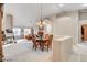 Elegant dining area featuring a chandelier, ample natural light, and adjacent living spaces at 6143 Basilone Ave, Las Vegas, NV 89122