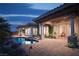 Lush backyard featuring a pool, spa, covered patio, and stone pillars, creating a serene outdoor space at 64 Tapadero Ln, Las Vegas, NV 89135