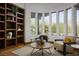 Bright living room with built-in shelving, natural light, and views of the landscaped backyard at 64 Tapadero Ln, Las Vegas, NV 89135