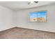Bedroom featuring neutral carpet, a large window, and ample natural light at 6445 Ironbark Ln, Las Vegas, NV 89107
