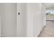 Neutral-toned hallway featuring wall storage and carpeted floors leading to a bright window at 6445 Ironbark Ln, Las Vegas, NV 89107