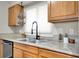 Well-lit kitchen features granite counters, a modern faucet, and wooden cabinets at 6445 Ironbark Ln, Las Vegas, NV 89107