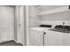 Functional laundry room featuring a washer and dryer, plus storage shelving at 6445 Ironbark Ln, Las Vegas, NV 89107