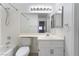 White bathroom with a shower-tub combination, a large vanity mirror, and modern lighting at 6871 Tamarus St # 204, Las Vegas, NV 89119