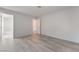Open bedroom with wood floors leading to a hallway with bathroom and closet doors visible at 6871 Tamarus St # 204, Las Vegas, NV 89119