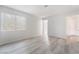 Bright bedroom with wood floors and a window showcasing natural light, door to hall and bathroom at 6871 Tamarus St # 204, Las Vegas, NV 89119