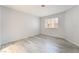Bright, empty bedroom with light-colored hardwood floors and natural light from a window at 6871 Tamarus St # 204, Las Vegas, NV 89119