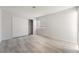 Spacious bedroom featuring wood floors, sliding closet doors, and natural light from the window at 6871 Tamarus St # 204, Las Vegas, NV 89119