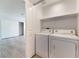 Modern laundry room featuring a washer, dryer, and storage space at 6871 Tamarus St # 204, Las Vegas, NV 89119