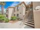 Inviting condo exterior with stairs, highlighted by manicured landscaping and mature palms at 7400 W Flamingo Rd # 1082, Las Vegas, NV 89147