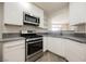 Modern kitchen with white cabinets, stainless steel appliances, and a view into the living area at 7400 W Flamingo Rd # 1082, Las Vegas, NV 89147