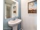 Elegant powder room features a pedestal sink, decorative mirror, and neutral color scheme at 7915 Pandora Sky St # 402, North Las Vegas, NV 89084