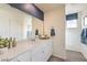 Modern bathroom features white cabinets, quartz countertop and a large mirror at 7915 Pandora Sky St # 402, North Las Vegas, NV 89084