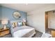 Bedroom with a white bed, blue accent wall, and a round mirror at 7915 Pandora Sky St # 402, North Las Vegas, NV 89084